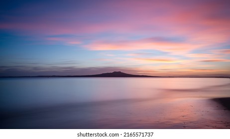 Milford Beach at dawn with Rangitoto Island in the distance, Auckland. 