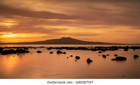 Milford beach at sunrise with Rangitoto Island in the background