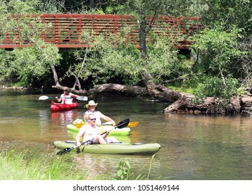 Milford, MI/USA: July 29, 2017 – Summer Scene Of Adults In Colorful Canoes And Kayaks Cluster On The Huron River Water Trail, A 104 Mile Inland Paddling Trail In The Lower Peninsula Of Michigan. 