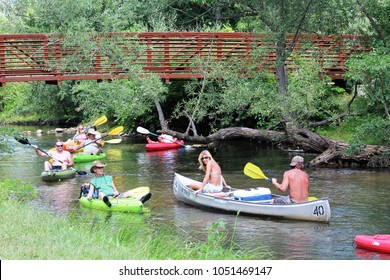 Milford, MI/USA: July 29, 2017 – Summer Scene Of Adults In Colorful Canoes And Kayaks Cluster On The Huron River Water Trail, A 104 Mile Inland Paddling Trail In The Lower Peninsula Of Michigan. 