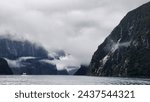 Milford Sounds low clouds boat mountains water lake
