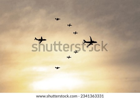 military aircraft in formation in the sky at sunset