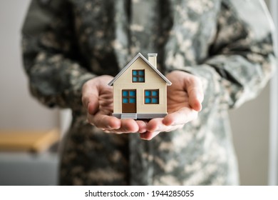 Military Army Man In Uniform Holding New House - Powered by Shutterstock