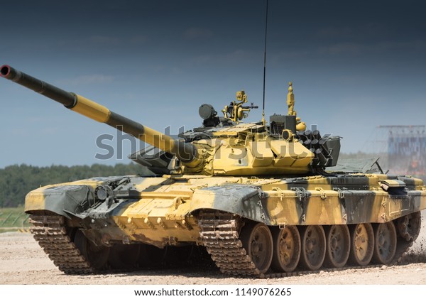 Military or army tank ready\
to attack and moving over a deserted battle field terrain. a lot of\
dust.