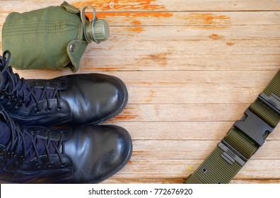 Military back pack for soldier,Military combat boots,Army water canteen on wooden background,top view for copy space