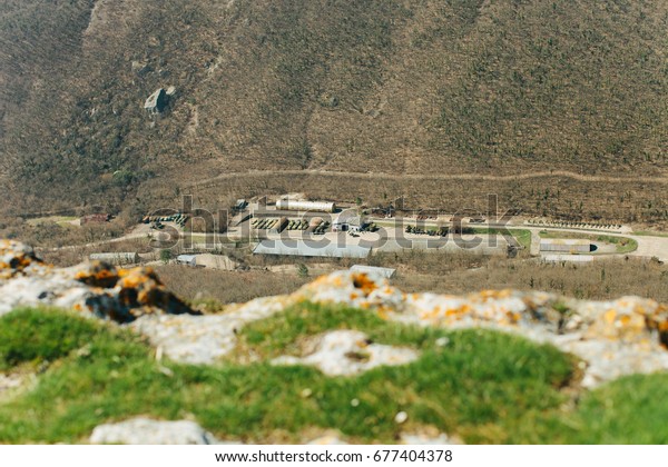 Military base in Bakhchisarai. Secret military
base a top view. Military unit in Crimea, Russia. Tanks, armored
personnel carriers,guns. War zone. Mountainous landscape. Military
unit in the mountains
