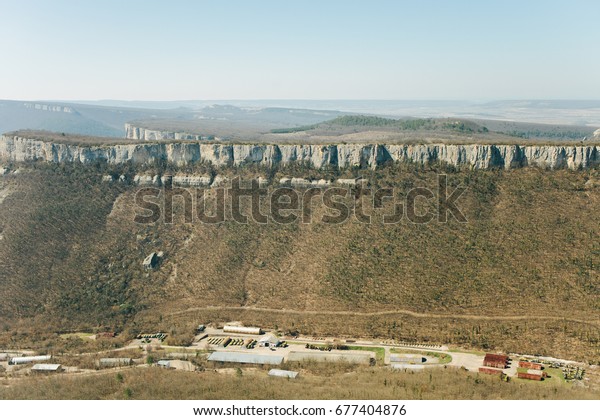 Military base in Bakhchisarai. Secret military\
base a top view. Military unit in Crimea, Russia. Tanks, armored\
personnel carriers,guns. War zone. Mountainous landscape. Military\
unit in the mountains