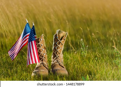 military boots near american flag with stars and stripes on grass  - Powered by Shutterstock