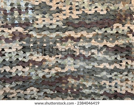 Military camouflage net, close-up. Mesh for camouflaging military equipment. Camouflage mesh weave for protection.