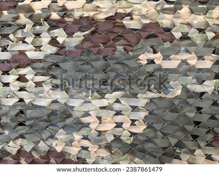 Military camouflage net, close-up. Mesh for camouflaging military equipment. Camouflage mesh weave for protection.