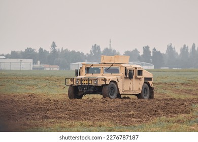 Military car in action. A car drives through a field with soldiers.