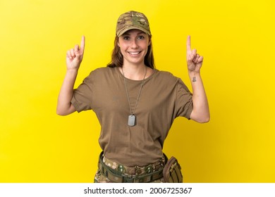 Military caucasian woman with dog tag isolated on yellow background pointing up a great idea