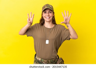 Military caucasian woman with dog tag isolated on yellow background counting eight with fingers