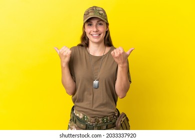 Military caucasian woman with dog tag isolated on yellow background with thumbs up gesture and smiling - Powered by Shutterstock