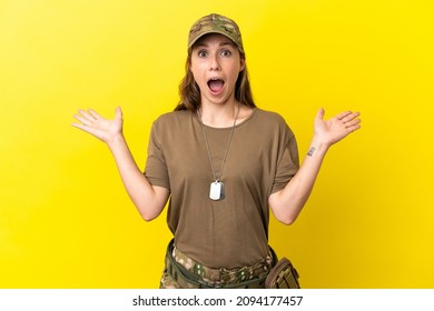 Military caucasian woman with dog tag isolated on yellow background with shocked facial expression