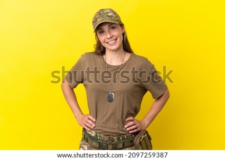 Military caucasian woman with dog tag isolated on yellow background laughing