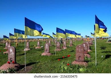Military cemetery in Ukraine. Soldiers of Ukrainian army who died in Russian war against Ukraine are buried here. National flag of Ukraine flutters over monuments. Dnipro, Ukraine, 07.05.2022.