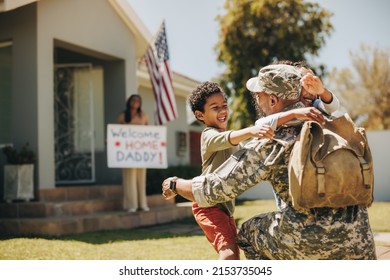 Military dad reuniting with his family at home. American soldier embracing his children after coming back home from the army. Serviceman receiving a warm welcome from his family. - Powered by Shutterstock