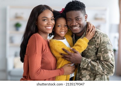 Military Family. Portrait Of African American Male Soldier With Wife And Little Daughter Posing At Home, Smiling Black Man In Camouflage Uniform Embracing With Spouse And Female Child, Closeup