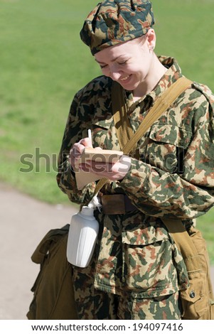 Military female writing in notebook outdoor