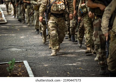 The Military Go In Camouflage And Rifles On Their Shoulders. Marching Feet Of Dirty Soldiers Who Are Returning From The Front From The War In Ukraine. Berets And Kalashnikov Assault Rifles.