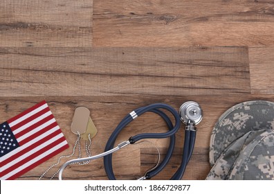 Military Health Care Concept. Camo Hat, Dog Tags, Stethoscope, Pills, And American Flags On A Wood Background. 