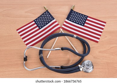 Military Health Care Concept. Light Wood Background With Stethoscope And Two Crossed American Flags.