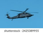 Military helicopter flying against the blue sky. Blackhawk helicopter