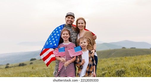 Military Homecoming. Young Military Man Soldier Happy To Be Reunited With His Patriotic Family,  Wife And Two Kids With American Flags Meeting Father From US Army On July 4th