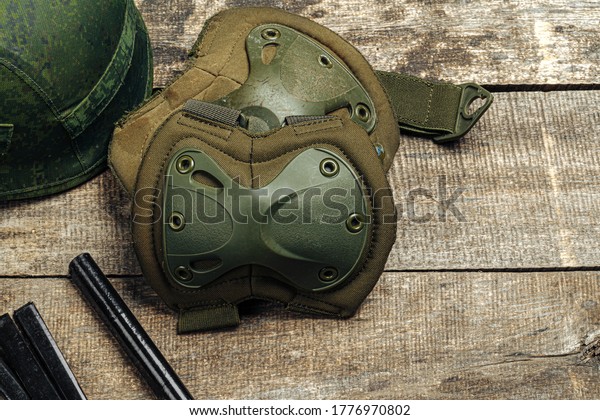 Military knee pads\
on wooden surface close\
up