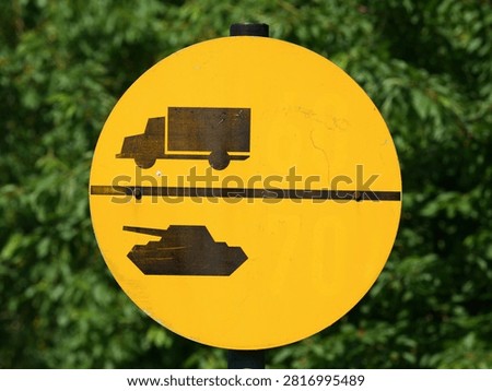 Military Load Classification (MLC) sign, a round, yellow sign indicating the load-bearing capacity of bridges within NATO
