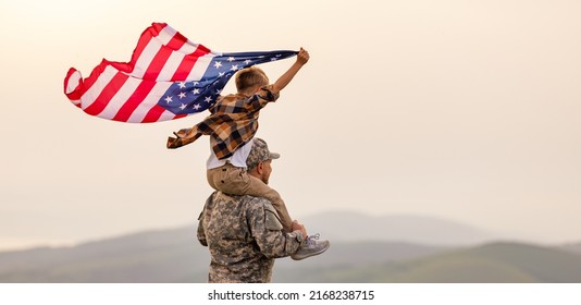 Military man father carrying happy little son with american flag on shoulders and enjoying amazing summer nature view on sunny day on July 4th, happy male soldier dad reunited with son after US army