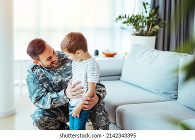 Military Man Father Hugs Son. Portrait Of Happy American Family. A Military Dad And His Son Are Hugging In Their Living Room. The Son Is Smiling Happily