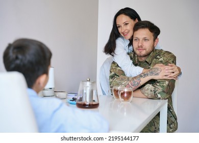 Military Man At Home Having Morning Tea With Family