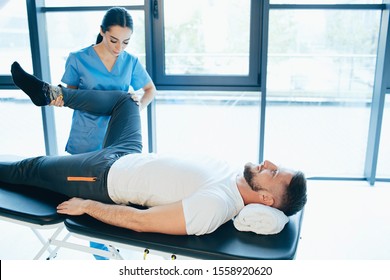 Military man rehabilitation after injury. man lying on massage table while his physical therapist doing special exercises for recovery - Powered by Shutterstock