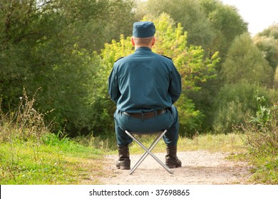 Military Man Sitting Back On The Camp Chair Outdoors