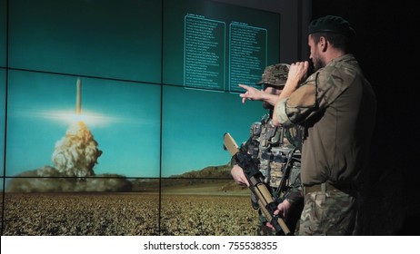 Military Men In System Control Area Watching Nuclear Missile Launch Looking At Digital Screen.