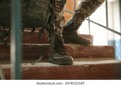 Military mission. Soldier in uniform on stairs inside abandoned building, closeup - Powered by Shutterstock