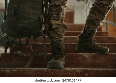 Military mission. Soldier in uniform on stairs inside abandoned building, closeup - Powered by Shutterstock