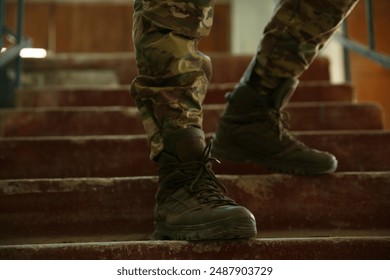 Military mission. Soldier in uniform on stairs inside abandoned building, closeup - Powered by Shutterstock