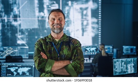 Military Officer Posing in Front of the Camera, Crossing Arms and Smiling. He is Standing in Surveillance Office for Cyber Operations and Managing National Security, Technology and Army Communications - Powered by Shutterstock