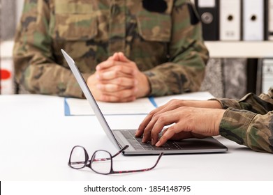 Militärische Offiziere treffen sich, um über Rekrutierung zu diskutieren. Sie benutzen einen Laptop.