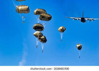Military parachutist paratroopers parachute jumping out of a air force planes on a clear blue sky day. - Shutterstock ID 2038481900