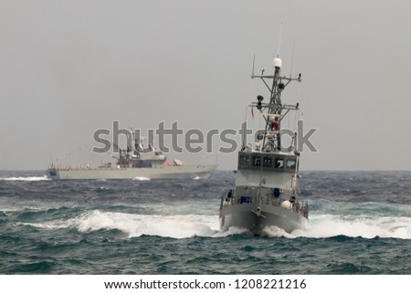 Military patrol boats entering port.