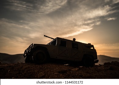 Military Patrol Car On Sunset Background. Army War Concept. Silhouette Of Armored Vehicle With Gun In Action. Decorated. Selective Focus