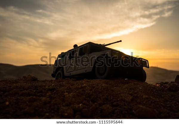 Military patrol car on sunset background. Army war\
concept. Silhouette of armored vehicle with gun in action.\
Decorated. Selective\
focus