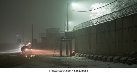 Military Patrol At Night Along T Wall On Bagram Air Base During Snow Storm