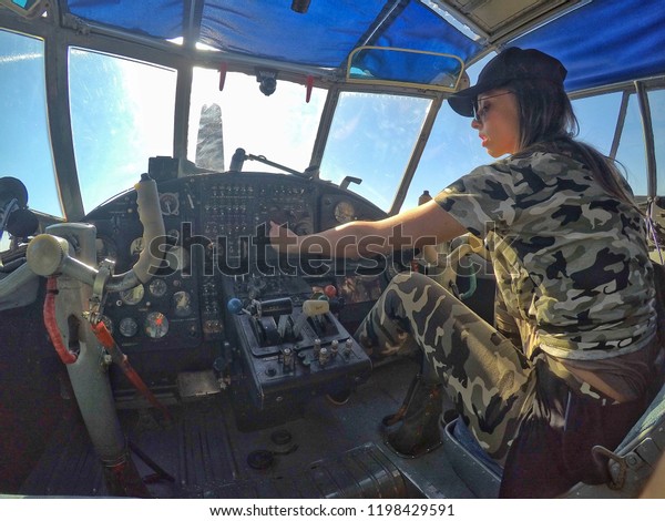 Military\
Pilot (Woman), Operating (Flying) An Old\
Plane