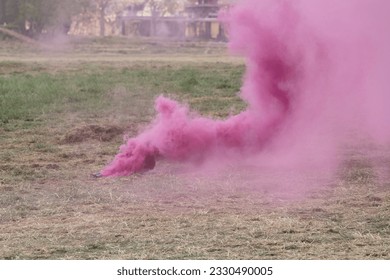Military pink smoke screen on the grass