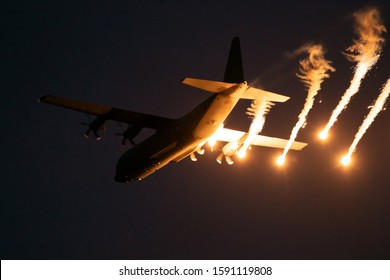 Military plane firing flares during a  night flight. - Powered by Shutterstock